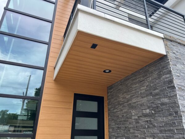Replaced wood siding with Sagiper SagiWall v groove siding in Caramel Zebra color and front entrance ceiling with SagiRev soffit in same color